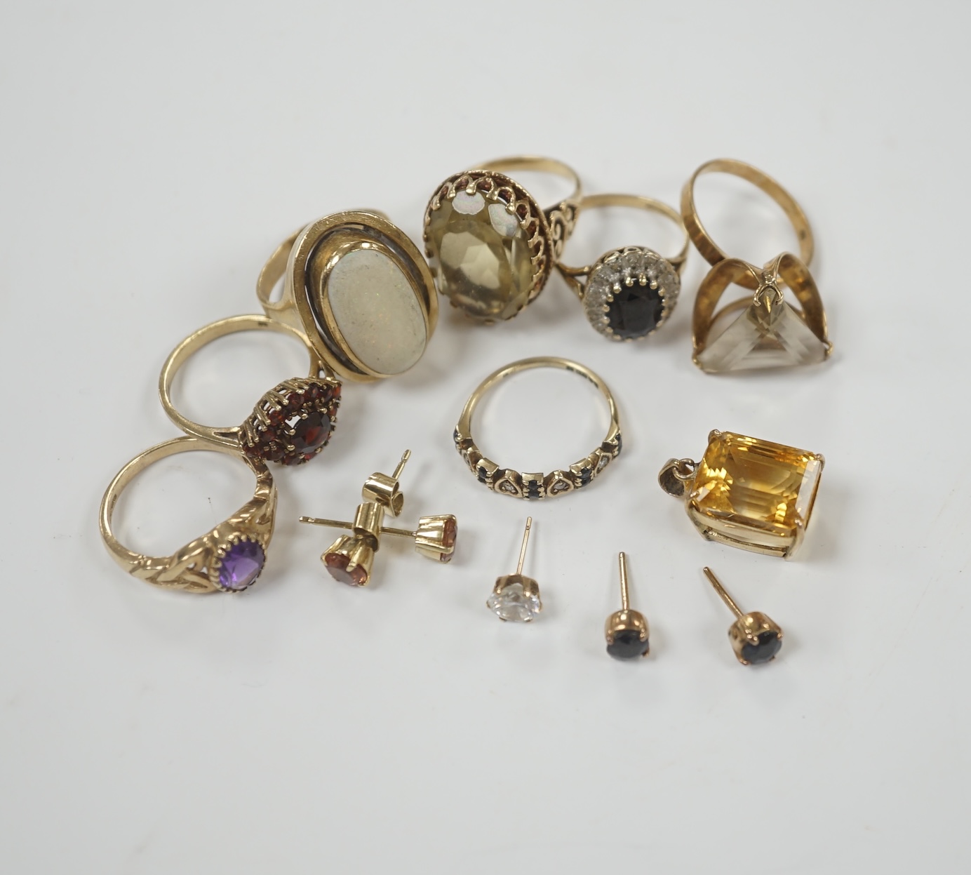 Seven assorted modern 9ct and gem set rings, including garnet cluster, white opal and amethyst, gross weight 26.2 grams, together with a pendant and assorted ear studs.